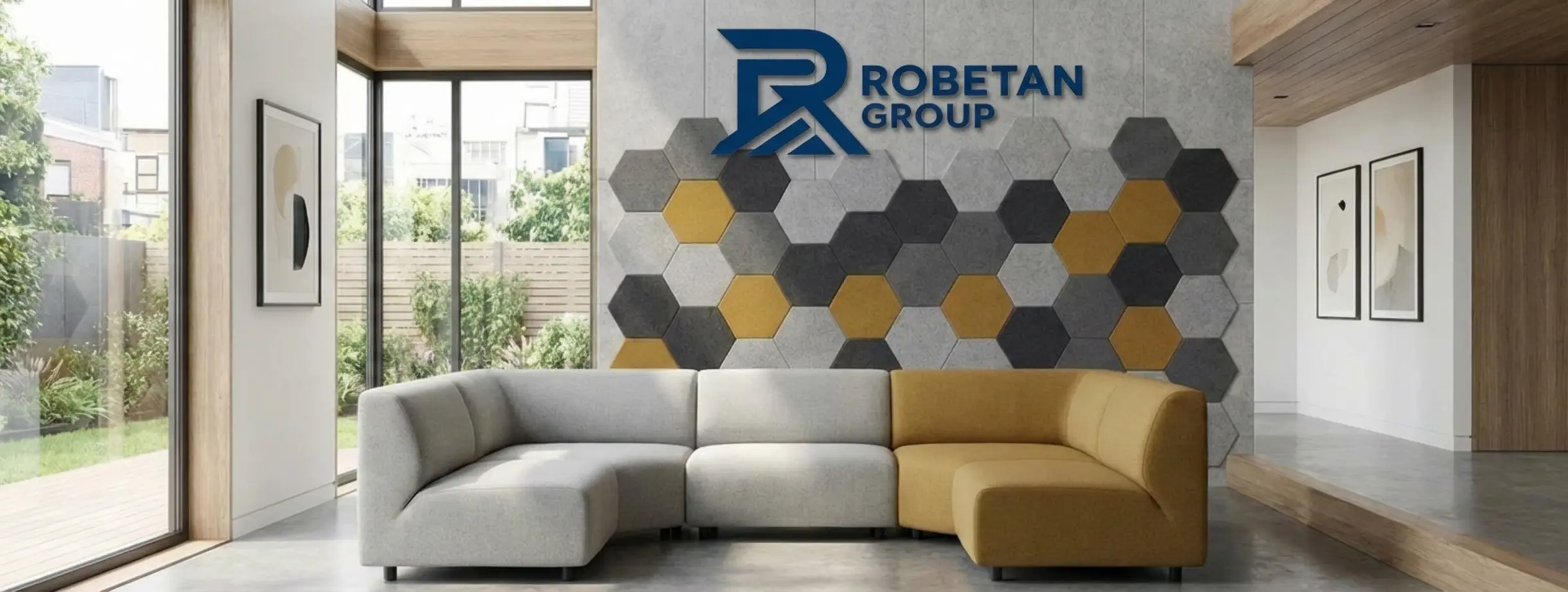 צילום של סלון מודרני מואר ומרווח הכולל ספה מעוצבת וקיר מרכזי שעליו מותקן פאנל אקוסטי דקורטיבי בצורת משושים בגווני אפור וחרדל המשתלבים בהרמוניה עם עיצוב החלל